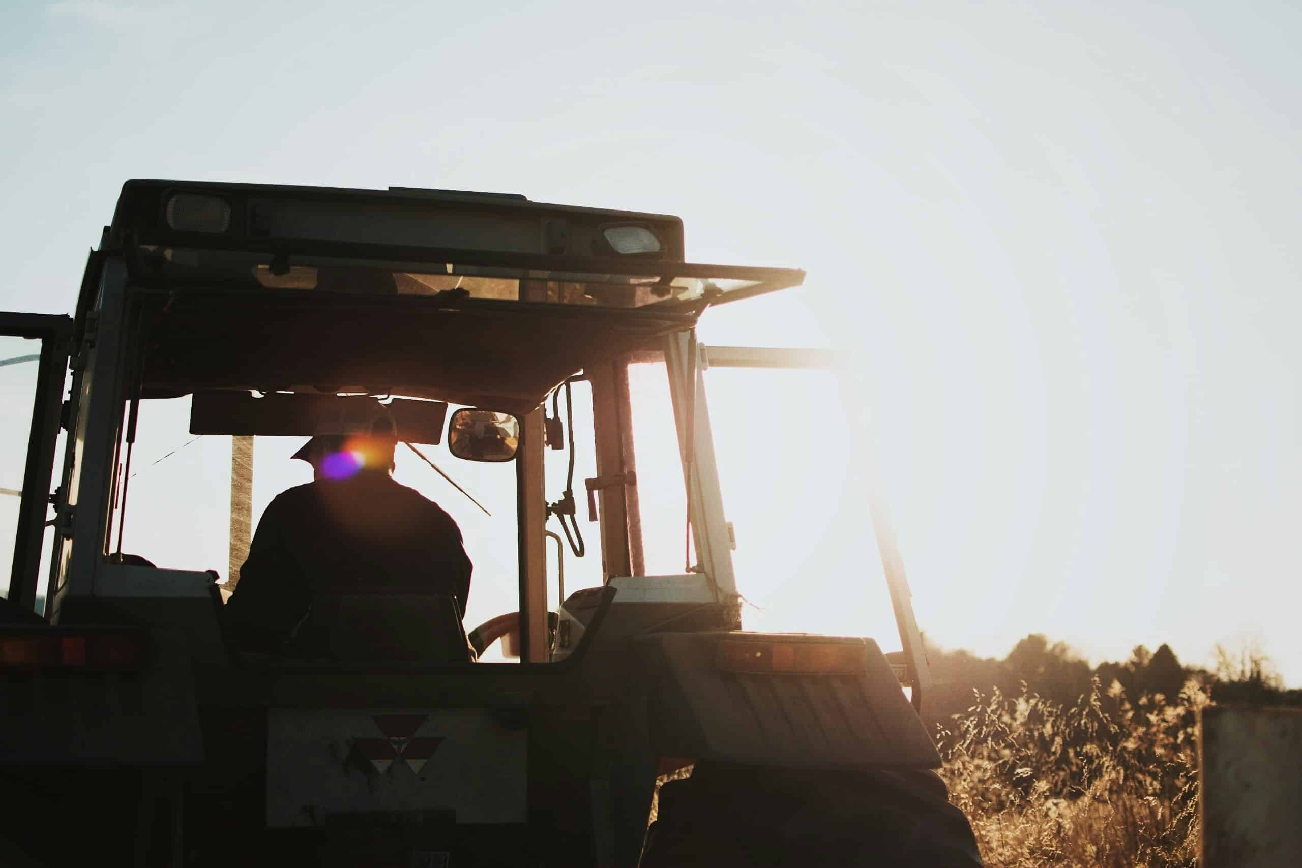 Farmer driving his tractor through a crop field