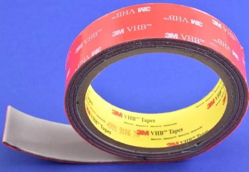 A roll of 3M tape that's red on the outside and yellow on the inside